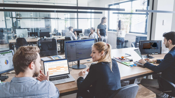 Scale your DaaS offering with us! people working in an office with multiple IT devices